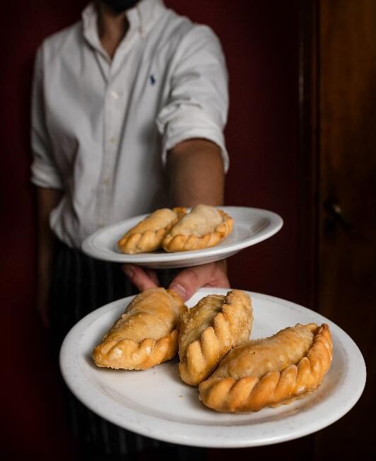 Mozo sirviendo empanadas